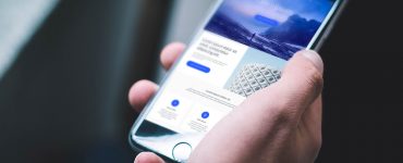 Black iPhone in Hand Mockup Free PSD