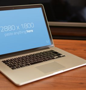 Macbook Pro on wooden table Mockup Free PSD