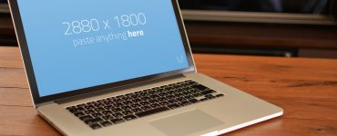 Macbook Pro on wooden table Mockup Free PSD